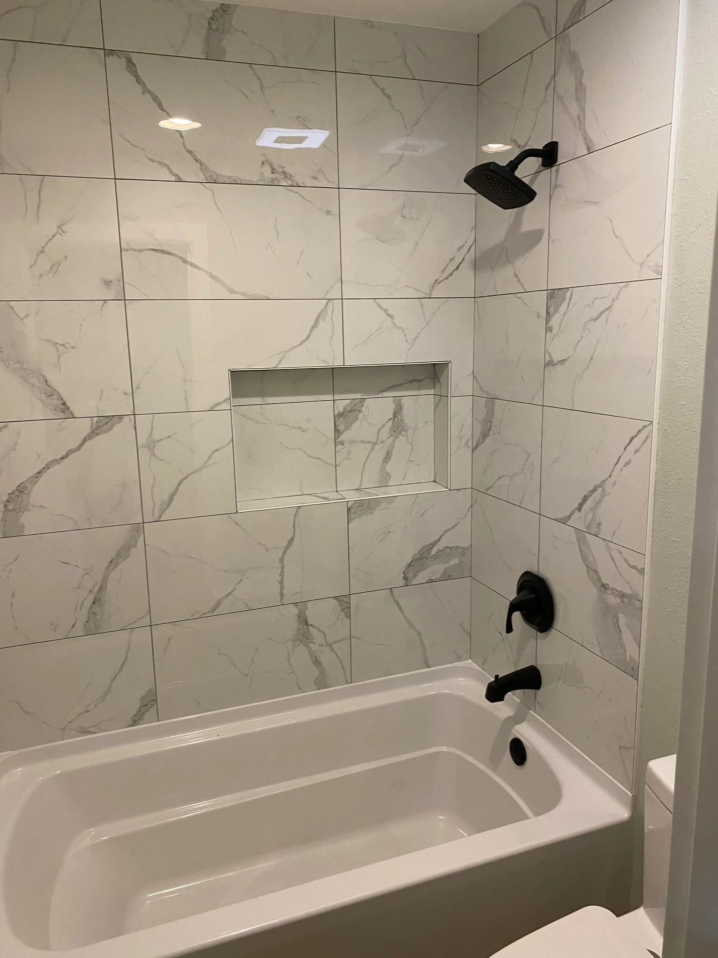 Renovated bathroom with marble shower and walk-in tub